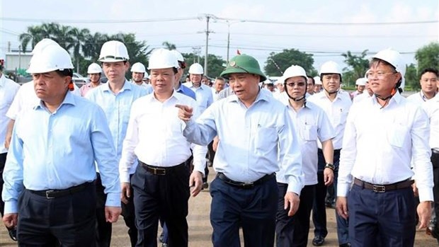 Le PM Nguyên Xuân Phuc (premier rang, au milieu) examine le rythme des travaux de construction de la zone de relogement Lôc An-Binh Son, district de Long Thành, province de Dông Nai. Photo : VNA.