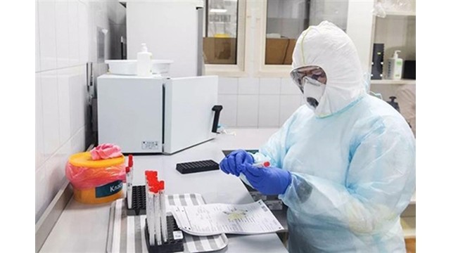Un chercheur examine l’échantillon d’un patient atteint du COVID-19 dans un laboratoire de Moscou, en Russie. Photo : RIA Novosti.