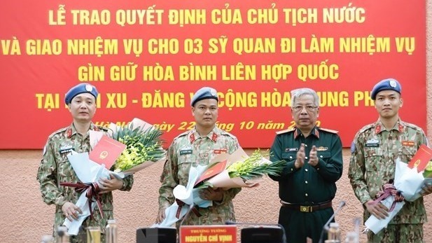Le général de corps d’armée Nguyên Chi Vinh remet la décision du Président de la République aux trois officiers. Photo : VNA.