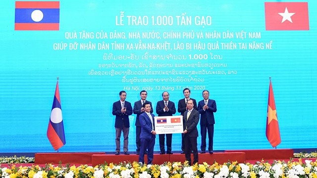 Sous le témoignage des Premiers ministres des deux pays, le vice-ministre des Affaires étrangères Nguyên Quôc Dung a remis symboliquement le don de 1 000 tonnes de riz à l'ambassadeur adjoint du Laos au Vietnam Chanthaphone Khammanichanh. Photo : https://baoquocte.vn