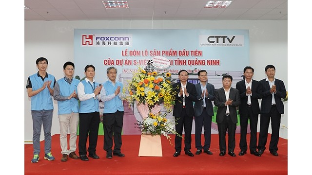 Le secrétaire du Comité municipal du Parti pour Quang Ninh, Nguyên Xuân Ky,  félicite le Foxconn Group pour son livraison du premier lot de produits. Photo : Journal Quang Ninh.