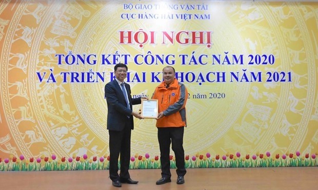 Le directeur de l’Administration maritime du Vietnam, Nguyên Xuân Sang, remet la lettre de félicitations de l’OMI au capitaine Dinh Xuân Manh. Photo : VNA.