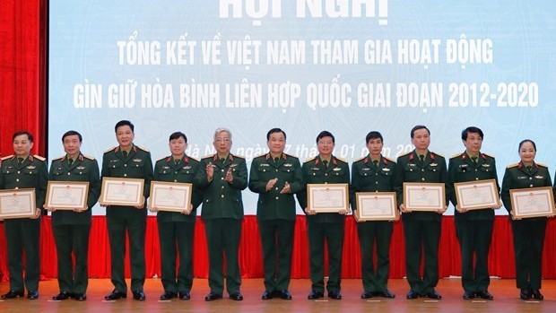 Le vice-ministre vietnamien de la Défense nationale, le lieutenant-général Nguyên Chi Vinh, remet des certificats de mérite à des collectifs et à des personnes ayant des réalisations exceptionnelles.  Photo : VNA.