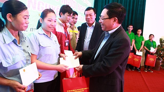 Le vice-premier ministre et ministre des Affaires étrangères, Pham Binh Minh, remet des cadeaux aux ouvriers. Photo: VGP