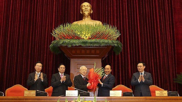 Au nom du Bureau politique, Nguyên Xuân Phuc (2e à partir de la droite), Premier ministre, offre des fleurs à Nguyên Phu Trong (3e à partir de la droite) qui a été réélu au poste de Secrétaire général du Comité central du PCV. Photo : VNA.