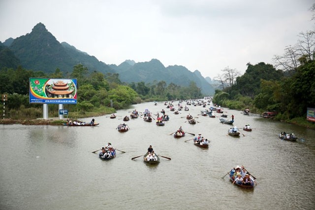 Les visiteurs prennent  de petits bateaux le long des voies navigables serpentant entre les falaises de calcaire pour accéder à la pagode des Parfums. Photo : kinhtedothi.vn.