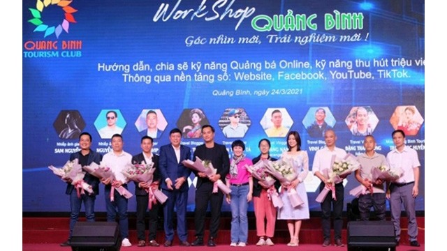 Le dirigeant du Service du Tourisme de Quang Binh offre des fleurs aux invités célèbres venus partager leur expérience dans la promotion du tourisme surles plateformes numériques. Photo : NDEL.