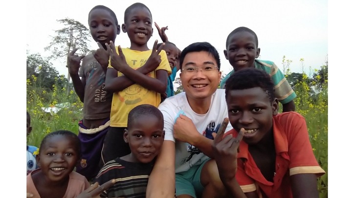 Quyêt prend une photo avec des enfants en Angola. Photo : Thoidai.