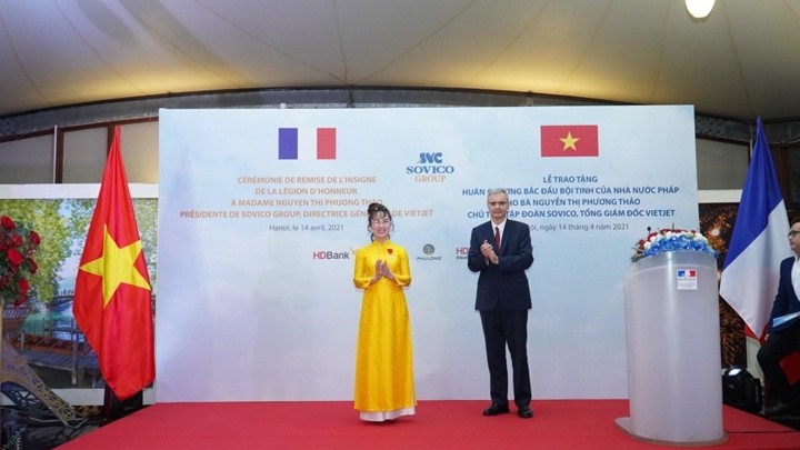 L’ambassadeur de France au Vietnam, Nicolas Warnery, remet l'insigne de la Légion d'honneur à Mme. Nguyen Thi Phuong Thao. Photo : VNA.
