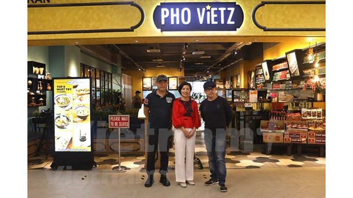 Tôn Ngoc Hiêp, 3e à gauche, devant son restaurant. Photo : VNA