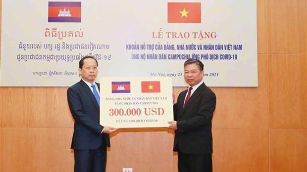 Le chef adjoint permanent de la Commission des relations extérieures du Comité central du Parti, Nguyên Huy Tang (à droite), présente une aide à l’ambassadeur du Cambodge au Vietnam Chay Navuth. Photo: VNA