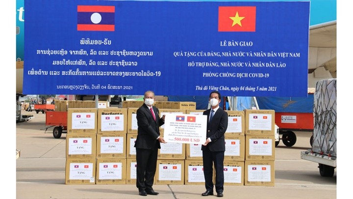 Le vice-ministre des Affaires étrangères, Tô Anh Dung, remet symboliquement une somme de 500 000 dollars au Laos, lors d'une cérémonie tenue le 4 mai à Vientiane. Photo : NDEL.