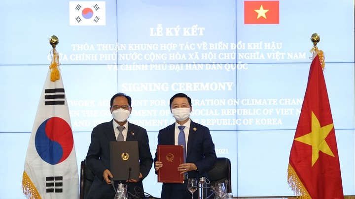 Le ministre des Ressources naturelles et de l'Environnement Trân Hông Hà (à droite) et l'ambassadeur de la République de Corée au Vietnam Park Noh-wan signent l'Accord-cadre de coopération sur le changement climatique. Photo : VGP.