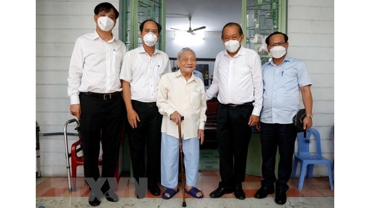 Le Vice-Premier ministre permanent Truong Hòa Binh (2e à partir de la droite) rend visite à l’invalide de guerre Nguyên Tho Chân, ancien ministre du Travail. Photo : VNA.