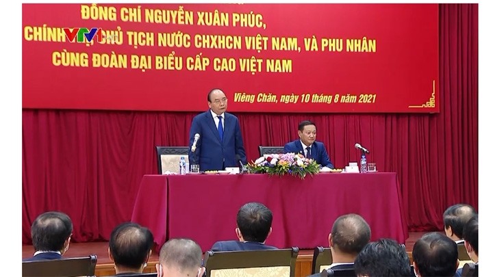Le Président Nguyên Xuân Phuc (debout) devant le personnel de l'ambassade et des représentants de la communauté vietnamienne au Laos. Photo : VTV/VOV.