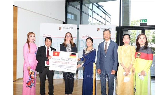 Le représentant de la communauté vietnamienne prsymboliquement présente 15 000 euros à Britta Lenz, représentante permanente de l'État de Rhénanie-Palatinat. Photo : VNA.