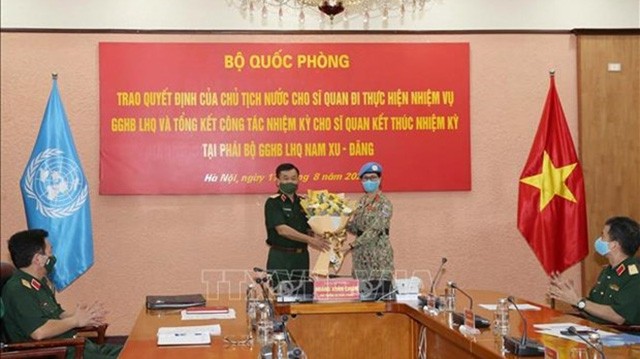 Le vice-ministre de la Défense, Hoàng Xuên Chiên, remet le décision à la lieutenant-colonelle Vu Thi Kim Oanh. Photo : VNA.