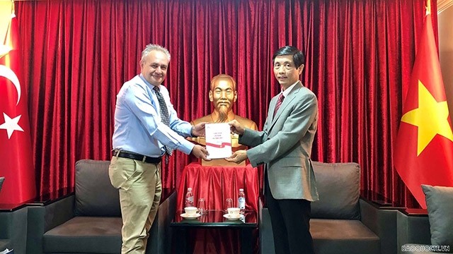Le professeur, docteur Merthan Dundar, directeur de l'APAM  offre un exemplaire du livre « Recherche sur le Vietnam en Turquie » à l'ambassadeur Trân Quang Tuyên. Photo : baoquocte.vn
