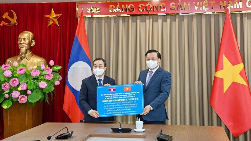 Le secrétaire du Comité du Parti de Hanoï, Dinh Tiên Dung (à droite), remet symboliquement des cadeaux de soutien à Vientiane et aux huit provinces du Nord du Laos. Photo : HNM.