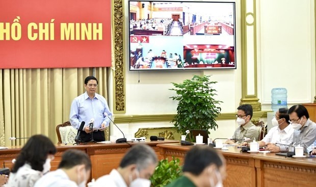 Le Premier ministre Pham Minh Chinh, chef du Comité national de Direction de la prévention et de la lutte contre le COVID-19, lors de la séance de travail avec les autorités de la mégapole du Sud. Photo : VNA.