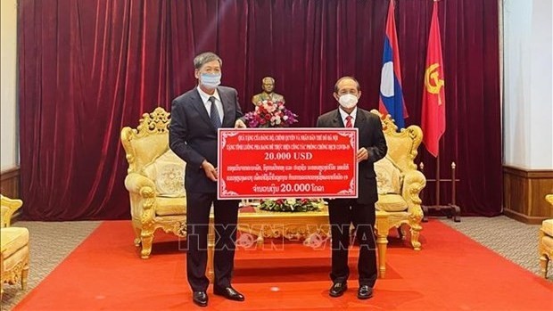 Le consul général du Vietnam à Luang Prabang au Laos, Nguyên Dang Hung (à gauche), a remis la somme de 20.000 dollars à Luang Prabang. Photo : VNA.