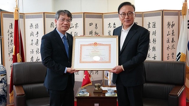 Le consul honoraire du Vietnam dans la circonscription consulaire de Busan-Gyeongnam en République de Corée, Park Soo-kwan, (à droite) lors de la remise du certificat de mérite décerné par le Premier ministre vietnamien, Pham Minh Chinh. Photo : baoquocte.vn.