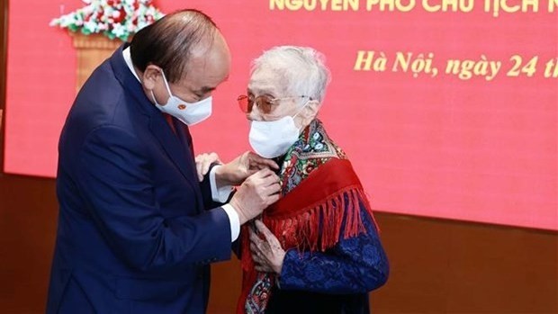 Le Président de la République, Nguyên Xuân Phuc, remet l’Insigne des «75 ans de membre du Parti » à l’ancienne Vice-Présidente Nguyên Thi Binh. Photo : VNA.