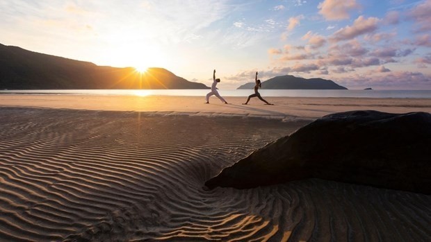 Les touristes combinent la méditation et le yoga le long de la côte de Con Dao. Photo : VNA.