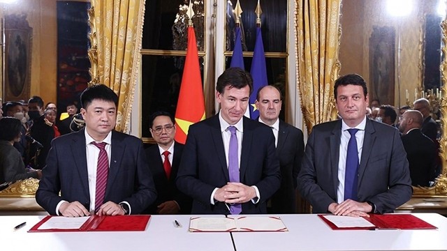 Lors de la signature d'un accord sur le lancement du satellite vietnamien d’observation de la Terre en présence des Premiers ministres vietnamien et français. Photo: congthuong.vn
