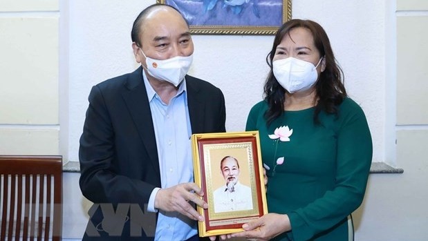 Le président Nguyên Xuân Phuc offre un cadeau de souvenir au professeur Triêu Thi Huê. Photo: VNA