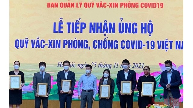 Le représentant du Groupe G.A. Consultants au Vietnam fait un don de 100 000 de dollars au Fonds de vaccine pour la prévention et le contrôle du Covid-19. Photo: NDEL