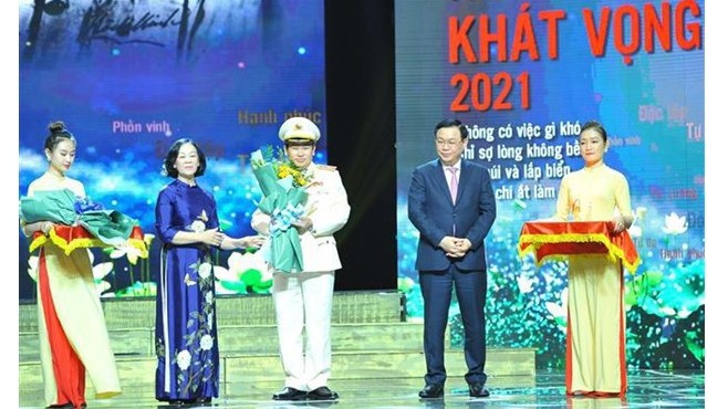 Le Président de l’Assemblée nationale Vuong Dinh Huê (2e à partir de la droite) remet un insigne à une personne exemplaire. Photo: VNA