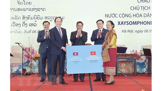 Le secrétaire du Comité du Parti de Hanoï, Dinh Tiân Dung, présente 5 milliards de dongs (217 000 de dollars) pour soutenir la lutte du Laos contre la pandémie de Covid-19.  Photo : VNA.