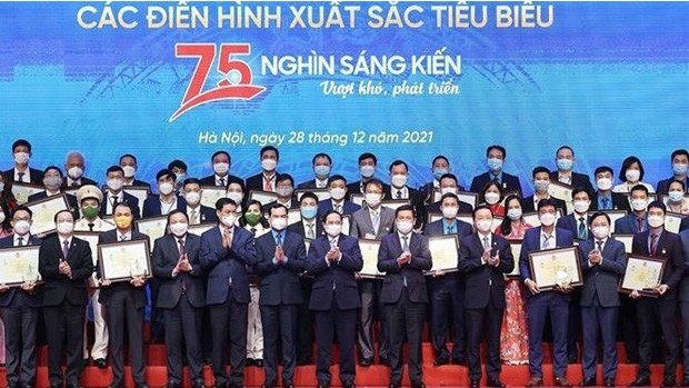 Le Premier ministre Pham Minh Chinh pose avec les lauréats du programme intitulé “75.000 initiatives pour surmonter les difficultés et se développer”. Photo : VNA