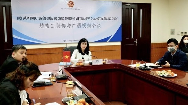 Des responsables du Département des marchés Asie-Afrique du ministère vietnamien de l'Industrie et du Commerce travaillent avec les responsables du  service du Commerce de la province du Guangxi.  Photo : VNA