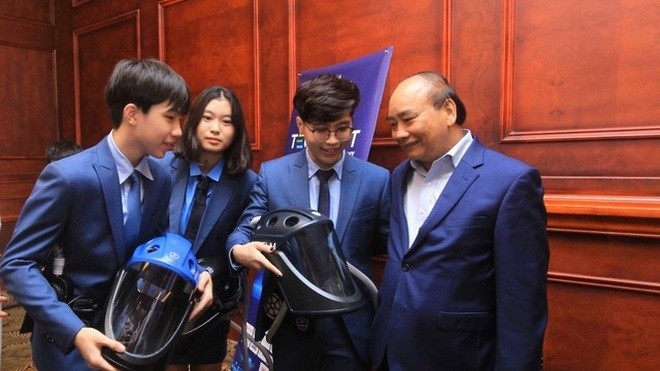 Le Président du Vietnam, Nguyên Xuân Phuc, et les concepteurs du "casque anti-épidémie Vihelm". Photo : VGP.
