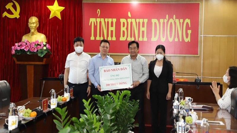Le rédacteur en chef du Journal Nhân Dân, Lê Quôc Minh (2e à partir de la gauche) remet 200 millions de dôngs à Binh Duong. Photo : NDEL.