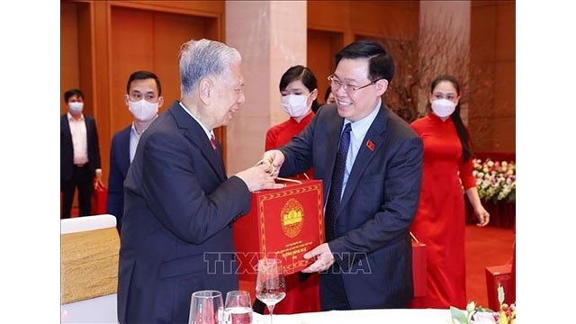 Le Président de l'AN Vuong Dinh Hue remis un cadeau à un dirigeant retraité. Photo : VNA