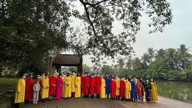 Des diplomates étrangers en "ao dai" prennent une photo lors de leur visite au village de Duong Lâm le 23 janvier. Photo: VNA