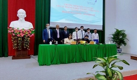 Deux entreprises taïwanaises signent des documents montrant leur engagement à investir à Vinh Long. Photo : doanhnghiephoinhap.vn