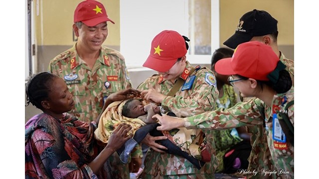 Dans le service d'obstétrique de l'hôpital général de Bentiu, la femme soldat Lê Na tient un nouveau-né dans ses bras. Photo : l'hôpital de campagne de niveau 2 No 3.