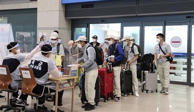 Des travailleurs vietnamiens effectuent des procédures d'immigration à l'aéroport d'Incheon, en République de Corée.