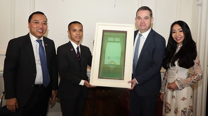 L'ambassadeur du Vietnam au Royaume-Uni, Nguyên Hoàng Long (premier, à gauche) offre une peinture au ministre d'État britannique au Cabinet Office, Nigel Adams (deuxième, à droite). Photo : VNA.
