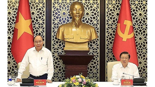 Le Président du Vietnam, Nguyên Xuân Phuc (à gauche), travaille avec la Direction chargée de la rédaction de la Stratégie d’édification de l’État de droit socialiste au Vietnam jusqu’en 2030, avec vision pour 2045. Photo : VNA.