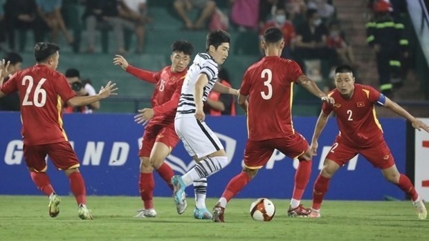 La défense de l'équipe du Vietnam (maillots rouges) entoure un joueur de l'équipe sud-coréenne. Photo : VNA.