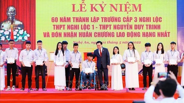 Le Président de l'AN, Vuong Dinh Huê (au centre), remet 60 bourses d'études à de meilleurs lycéens en situation difficile difficiles du lycée Nguyên Duy Trinh. Photo : hanoimoi.com.vn 