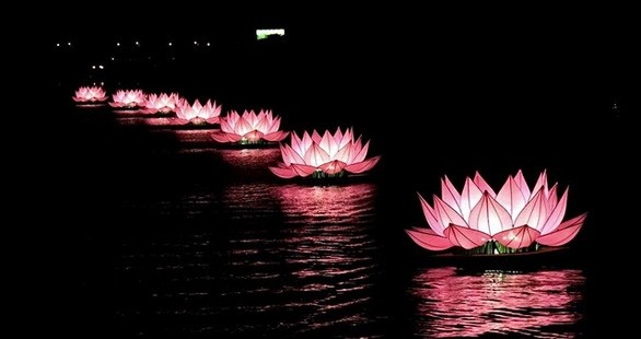7 fleurs de lotus illuminées sur la rivière Huong dans la soirée du 8 mai. Photo : tuoitre.vn.