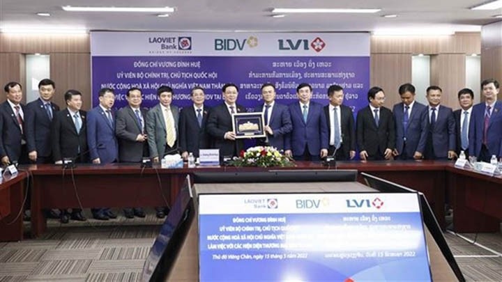 Le Président de l'AN du Vietnam, Vuong Dinh Huê, offre un cadeau au bureau de représentation du BIDV au Laos. Photo : VNA.