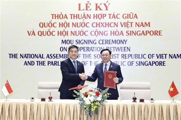 Le Président du Parlement singapourien Tan Chuan-Jine (gauche) et son homologue vietnamien Vuong Dinh Huê signent un accord de coopération pour continuer à renforcer leurs liens. Photo : VNA.