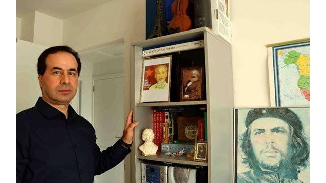 Ahmet Yasar et les photos de l'Oncle Hô dans le bureau de sa maison. Photo : VNA.